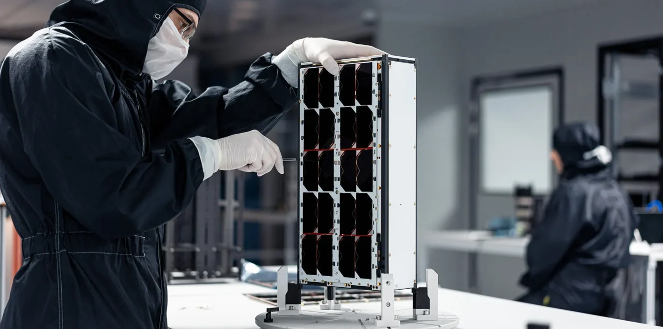 Engineer inspecting EnduroSat 8u cubesat during assembly in clean room