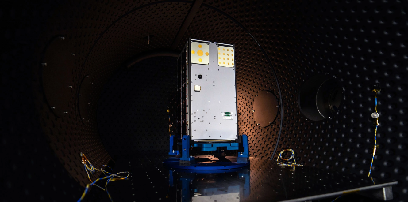 16 cubesat undergoing environmental testing inside a thermal vacuum chamber