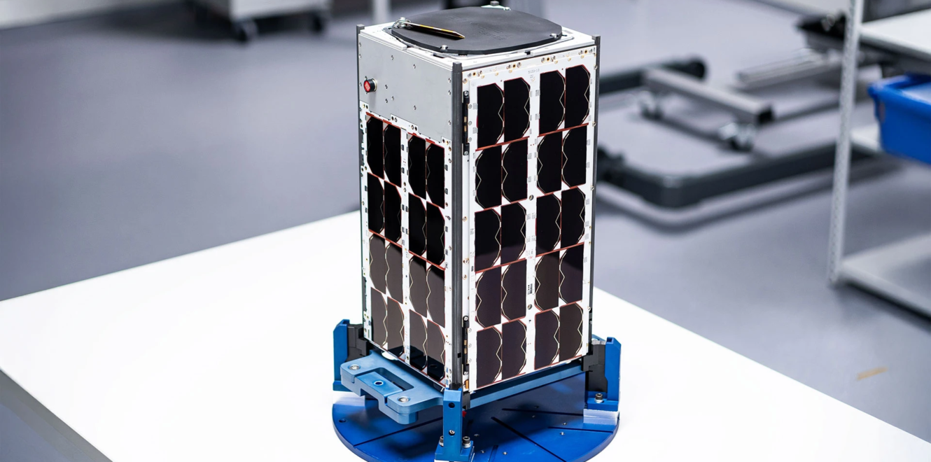 16 cubesat with integrated solar panels mounted on a ground test stand in a cleanroom facility