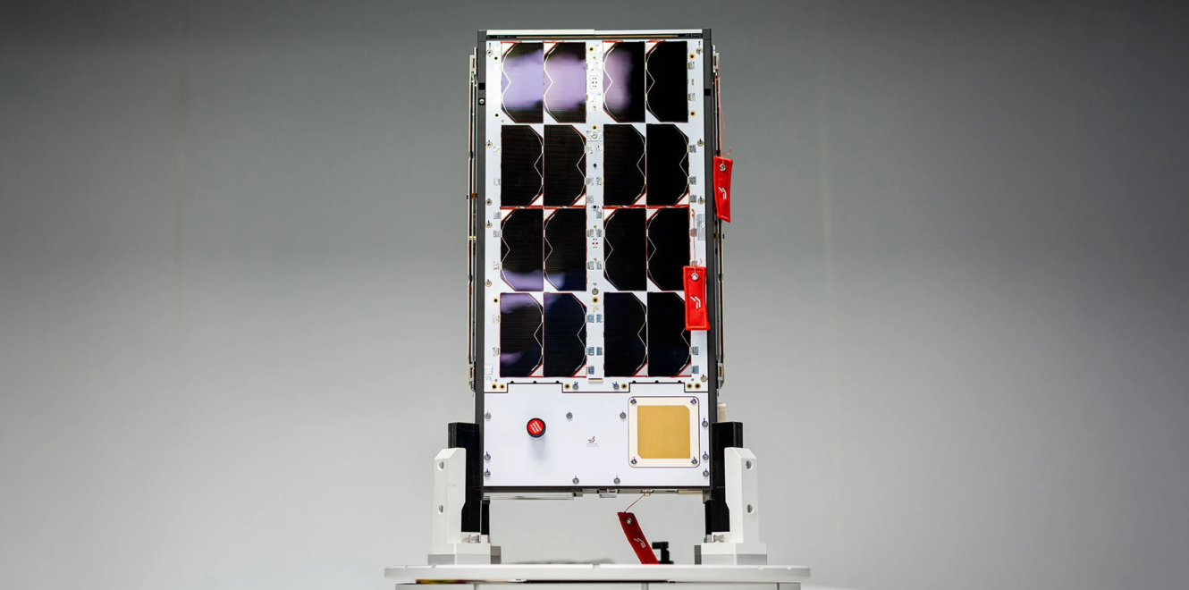 8u cubesat positioned on test stand displaying solar modules and subsystem interfaces
